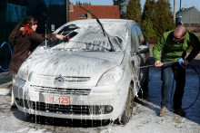 Un couple lave sa voiture dans une station de lavage automobile (illustration )