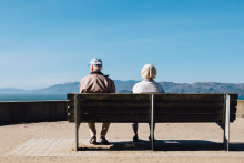 Un couple de seniors assis sur un banc.