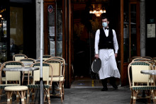 Un serveur devant un café parisien durant la pandémie de nouveau coronavirus.