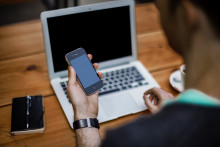 Un homme avec un smartphone et un ordinateur portable (illustration)