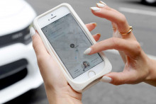 Une femme commande un Uber sur son smartphone (illustration)
