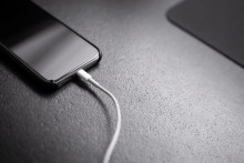 Un téléphone branché à son chargeur (Illustration).