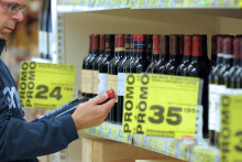 Un homme choisit du vin dans un supermarché pendant la foire aux vins