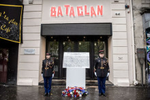 Deux officiers se tiennent à côté de la plaque commémorative dévoilée au Bataclan.