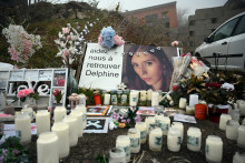 Une photo prise le 17 janvier 2022 montre des bougies et des fleurs devant la maison de Cédric et Delphine Jubillar (portrait) à Cagnac-les-Mines. 