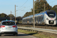 Une voiture et un train se croisent.