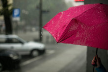 Une femme se protège de la pluie. (illustration)
