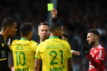 L'arbitre français Johan Hamel met un carton jaune au défenseur nantais Jean-Charles Castelletto lors du match de football de Ligue 1 entre Brest et Nantes au stade Francis Le Blé à Brest, le 10 avril 2022.