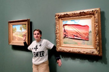 Une militante de Riposte Alimentaire pose après avoir recouvert un tableau de Claude Monet d'un autocollant représentant la même scène en l'an 2100, ravagée par la sécheresse, au Musée d'Orsay, à Paris.