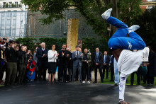 Danis Civil performe devant la ministre des Sports Amélie Oudéa-Castéra, le président français du comité d'organisation des Jeux de Paris 2024 Tony Estanguet (C-L) et le Premier ministre français Gabriel Attal à Paris le 25 avril 2024.