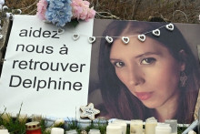 Une photo prise le 17 janvier 2022 montre des bougies et des fleurs devant la maison de Cédric et Delphine Jubillar (portrait) à Cagnac-les-Mines.