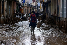 Un volontaire marche dans une rue boueuse alors qu'il quitte Paiporta, dans la région de Valence, dans l'est de l'Espagne, le 3 novembre 2024, à la suite d'inondations dévastatrices et meurtrières.