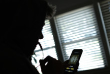 Un homme enregistre un message vocal sur un smartphone