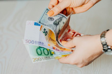 Une femme tient plusieurs billets de banque (illustration)
