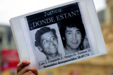 Une femme tient une affiche avec des photographies de Luis Guajardo et Sergio Tormen, qui font partie de la longue liste des disparus torturés sous la dictature (1973-1990) d'Augusto Pinochet, à Santiago le 26 août 2005.