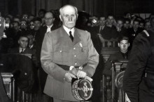 Le Maréchal Philippe Pétain arrive dans la salle d'audience lors de son procès durant l'été 1945 devant la Haute Cour de justice de Paris pour intelligence avec l'ennemi à l'issue duquel il sera condamné à mort, le 15 août 1945, à l'âge de 89 ans.