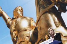 Marine Le Pen en meeting sur la place de l'Opéra, le 1er mai 2012, avec une photo de la statue de Jeanne d'Arc en fond