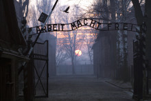 Cette photo montre le portail principal donnant accès au camp de la mort d'Auschwitz-Birkenau à l'aube. On peut lire le célèbre panneau à l'entrée du camp de concentration nazi polonais d'Auschwitz, "Arbeit macht frei" ou "Le travail vous libérera".