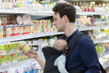 Un père avec sa fille bébé faisant les courses dans un supermarché.