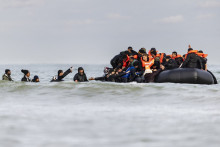 Des migrants montent à bord d'un bateau de passeurs pour tenter de traverser la Manche, sur la plage de Gravelines, près de Dunkerque, dans le nord de la France, le 26 avril 2024.