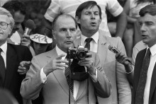 Le président français François Mitterrand prend des photos des cyclistes lors de la 12e étape (Morzine / Lans-en-Vercors) du Tour de France, le 10 juillet 1985, à Montaud, Isère.