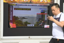 Un homme regardant les dernières nouvelles sur les alertes au tsunami au Japon, le 30 juillet 2025