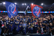 Les joueurs du PSG célébrant les quatre trophées remportés lors de la saison 2024-25 : la Ligue des Champions, la Ligue 1, la Coupe de France ainsi que le Trophée des Champions, au Parc des Princes (Paris).