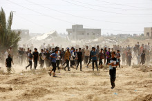 Des Palestiniens attendent dans l'espoir d'obtenir de l'aide alimentaire larguée par avion, à Gaza, le 9 août 2025.