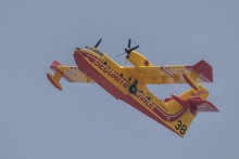 Cette photographie montre un Canadair CL-415 en vol, appartenant aux services de la Sécurité civile française, lors d'un incendie de forêt à Saint-Laurent-de-la-Cabrerisse, dans le sud de la France, le 7 août 2025.