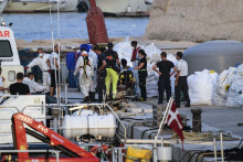 Des agents sanitaires viennent en aide à un marin tunisien secouru lors d'une mission de recherche et de sauvetage après le naufrage de plusieurs bateaux au large de Lampedusa, en Italie, le 14 août 2025.