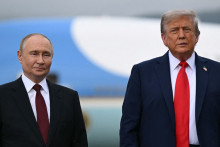 Donald Trump et Vladimir Poutine posent sur un podium sur le tarmac après leur arrivée à la base militaire Elmendorf-Richardson à Anchorage, en Alaska, le 15 août 2025.