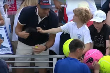 Un homme arrache la casquette offerte par un joueur de tennis à un enfant