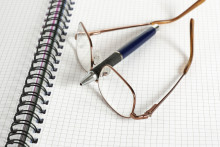 Un stylo et une paire de lunettes sur un cahier.