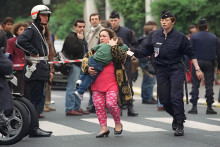 L'un des enfants libéré par "Human Bomb" l'homme armé qui a pris en otage les enfants d'une classe de l'école maternelle Commandant Charcot de Neuilly-sur-Seine, est emmené par sa mère et les policiers, le 13 mai 1993