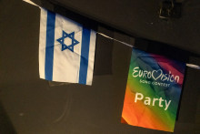 Un drapeau israélien est accroché à côté d'un drapeau de l'Eurovision lors d'une projection de la finale du Concours Eurovision de la chanson 2025 dans un centre communautaire à Tel Aviv, en Israël, le 17 mai 2025