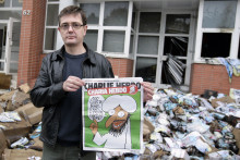 Charb, en 2011 devant les locaux de Charlie Hebdo, incendiés.