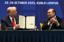 Donald Trump et Anwar Ibrahim tiennent des documents signés lors d'une réunion bilatérale en marge du 47e sommet de l'Association des nations de l'Asie du Sud-Est (ASEAN) à Kuala Lumpur le 26 octobre 2025.