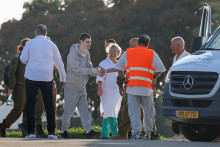 Des soldats et des médecins israéliens accompagnent Maxim Herkin, ex-otage du Hamas, à son arrivée au centre médical Sheba Tel-HaShomer à Ramat Gan, le 13 octobre 2025.