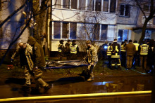 Des pompiers transportent un corps à l'extérieur d'un immeuble résidentiel endommagé à la suite de frappes de missiles et de drones russes à Kiev le 25 novembre 2025. De puissantes explosions ont secoué la capitale ukrainienne.