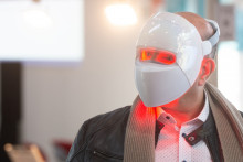 Un homme essaie un masque LED à lumière rouge