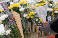 Les habitants de Hong-Kong déposent des fleurs sous le complexe résidentiel ravagé par les flammes