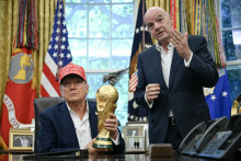 Le président américain Donald Trump avec le trophée de la Coupe du monde et le patron de la Fifa Gianni Infantino dans le bureau ovale, le 22 août 2025.