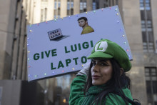 Une femme brandit une pancarte de soutien à Luigi Mangione devant le tribunal pénal de Manhattan avant son audience préliminaire pour meurtre. New York, États-Unis, 1er décembre.