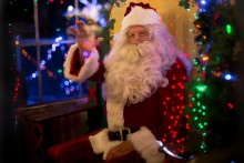 Le père Noël assis dans une maison. (Illustration)