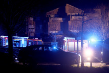 Des véhicules médicaux et de secours sont garés près du lieu d'une explosion dans un immeuble résidentiel à Trévoux, près de Lyon, qui a fait au moins quatre blessés et tué deux enfants, le 15 décembre 2025.