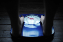 Une femme se pèse sur une balance. (Illustration)