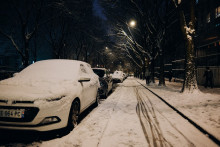 Des voitures garées recouvertes de neige et une piste cyclable enneigée le long de la rue Rebeval dans le quartier Belleville à Paris, le 5 janvier 2026.