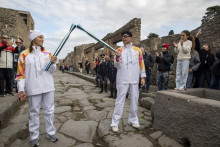 Le chanteur Stash et la nageuse Immacolata Cerasuolo tiennent la torche des Jeux olympiques d'hiver de Milan-Cortina sur le site archéologique de Pompéi, le 22 décembre 2025.