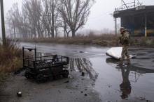 Un soldat ukrainien se tient devant un drone terrestre de ravitaillement en munitions qui a brûlé à la suite d’une probable frappe de drone russe, le 21 novembre 2025.