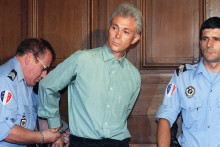 Yves Dandonneau se fait retirer les menottes par un policier, le 30 juin 1992, lors de l'ouverture de son procès devant les assises de l'Hérault